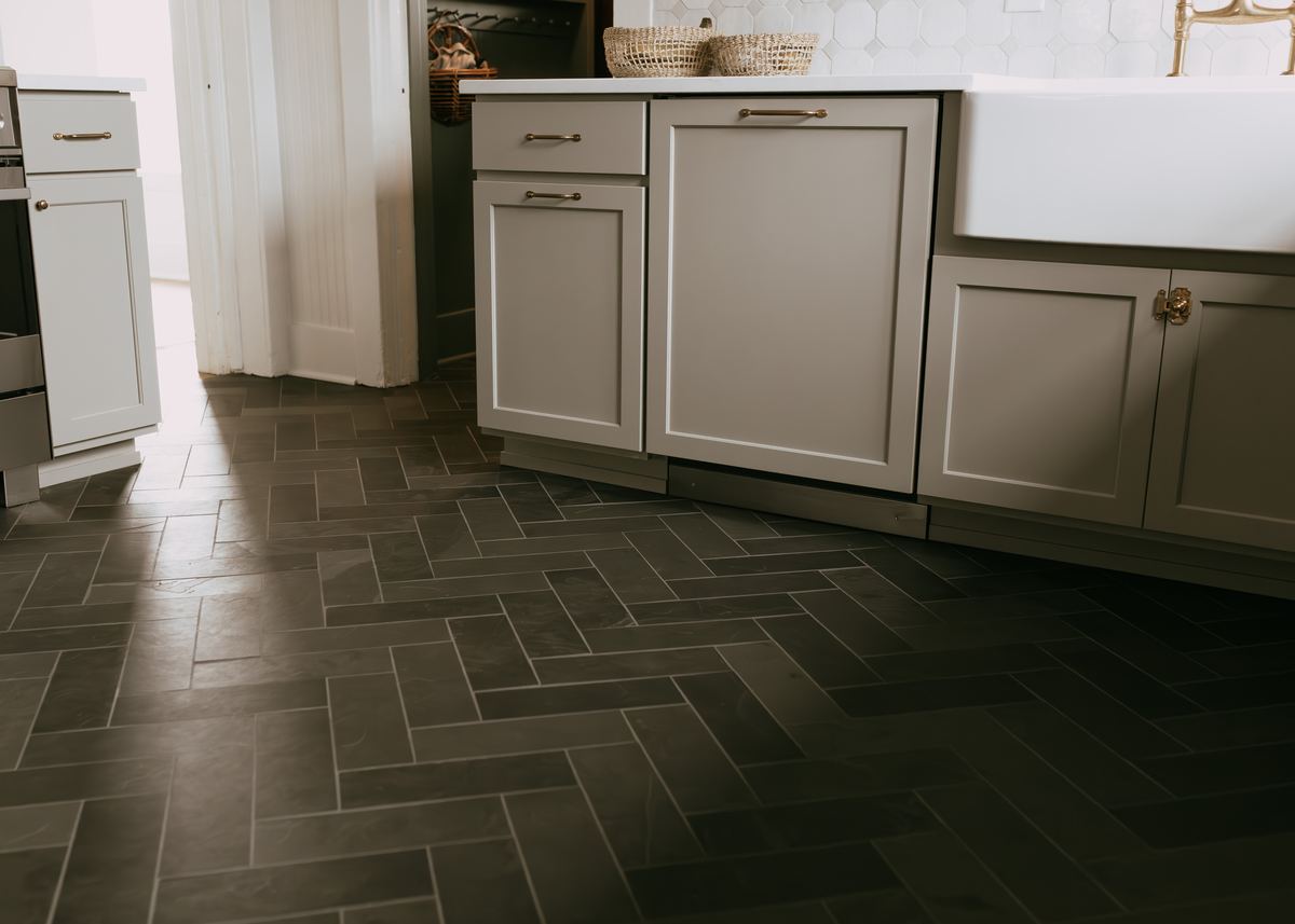 Charcoal herringbone tile floor in a remodeled kitchen